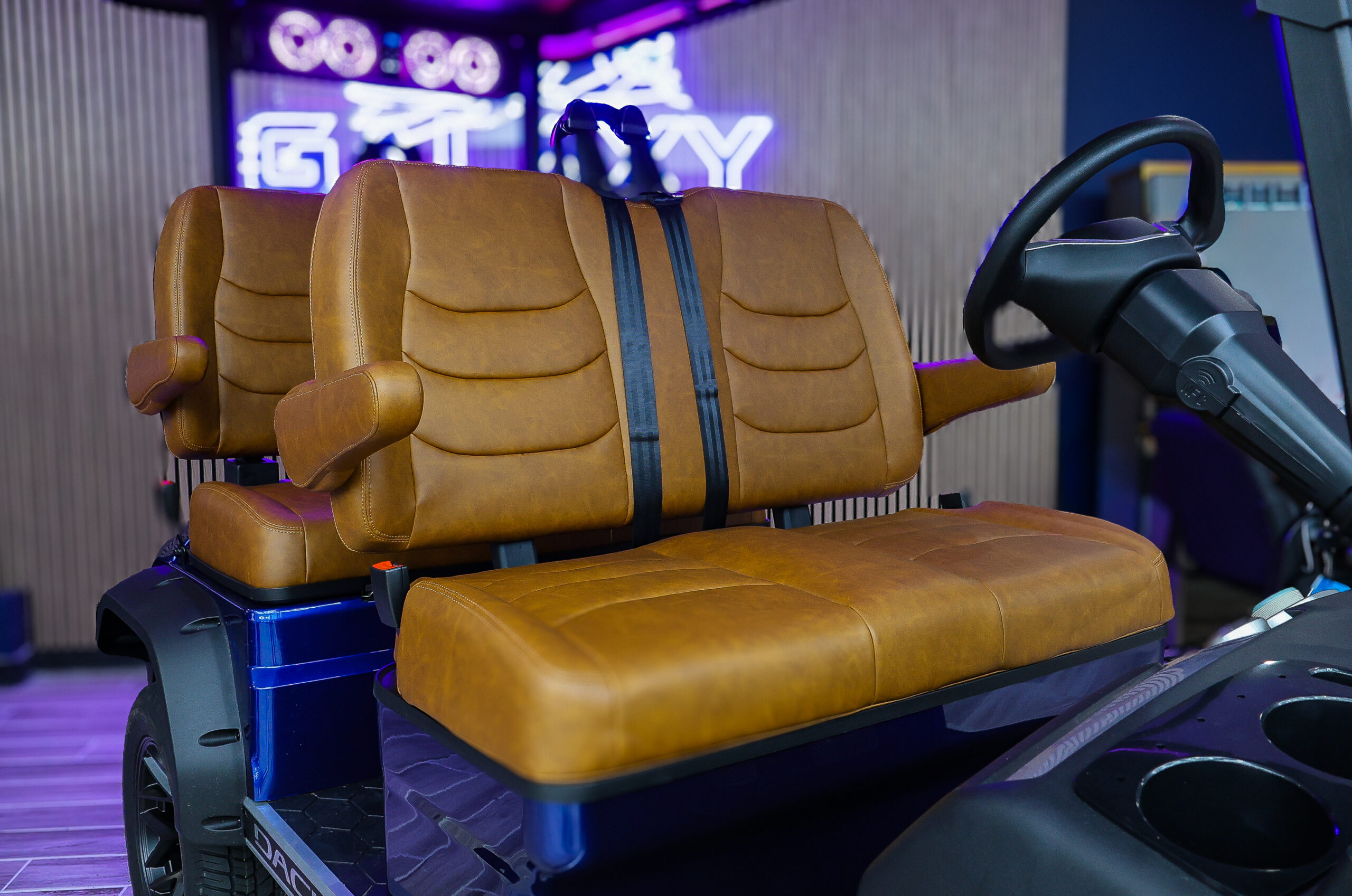 Premium brown leather seats with armrests on a blue Dach electric golf cart inside the Galaxy Golf Cars showroom