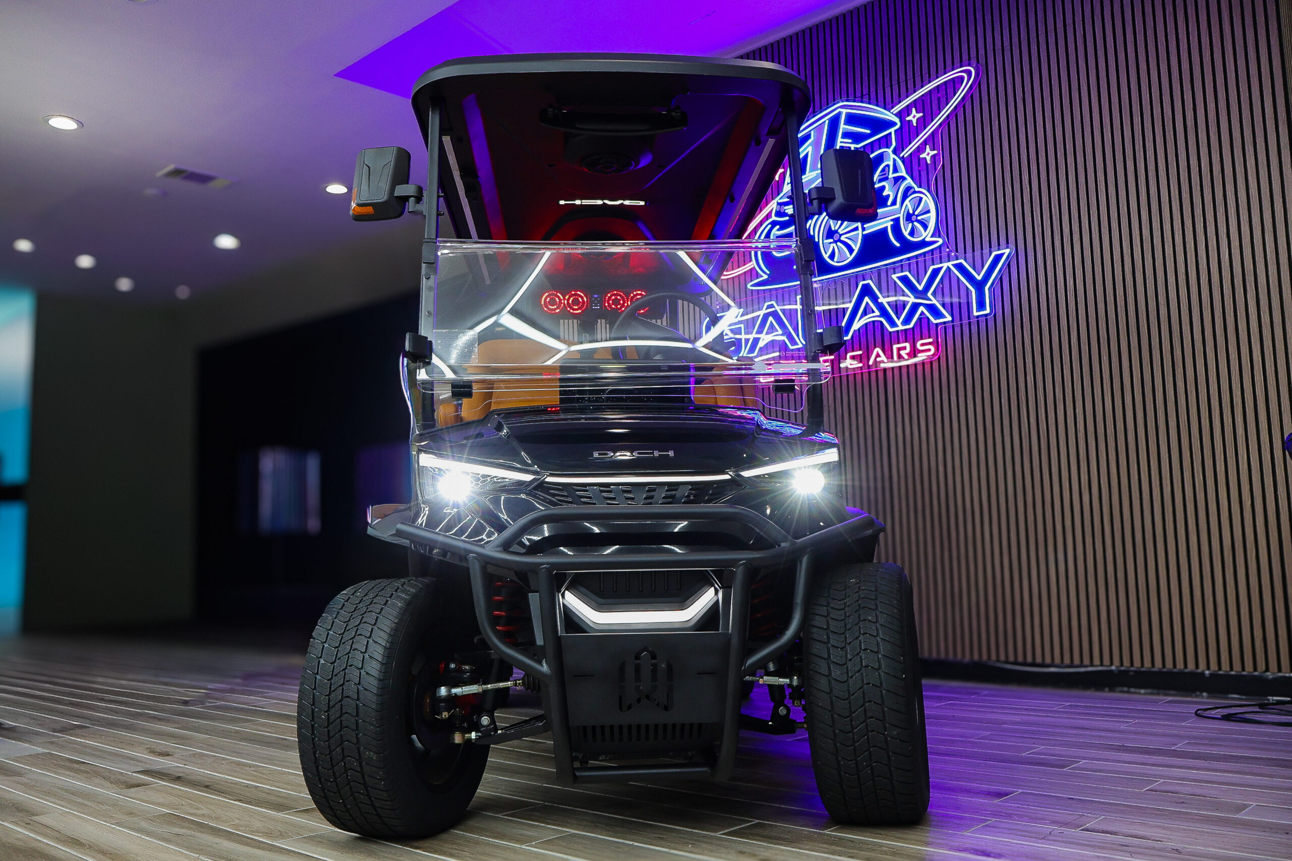 Front view of a black Dach 4-passenger electric golf cart with LED headlights and a rugged front brush guard at the Galaxy Golf Cars showroom