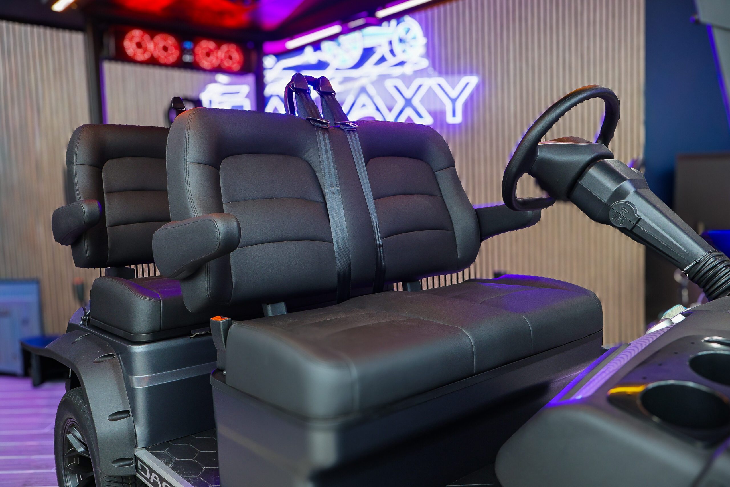 Premium black seats with armrests and seatbelts on a Dach electric golf cart inside Galaxy Golf Cars showroom
