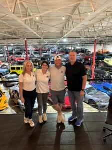 The Galaxy Golf Cars team stands with their loyal customer Peter at The Shop Club Dallas during an inspiring community-focused automotive event.