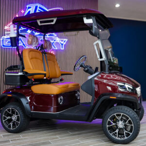 Side view of the Conquest S20 electric golf cart in burgundy with tan luxury seats and aluminum wheels at Galaxy Golf Cars showroom