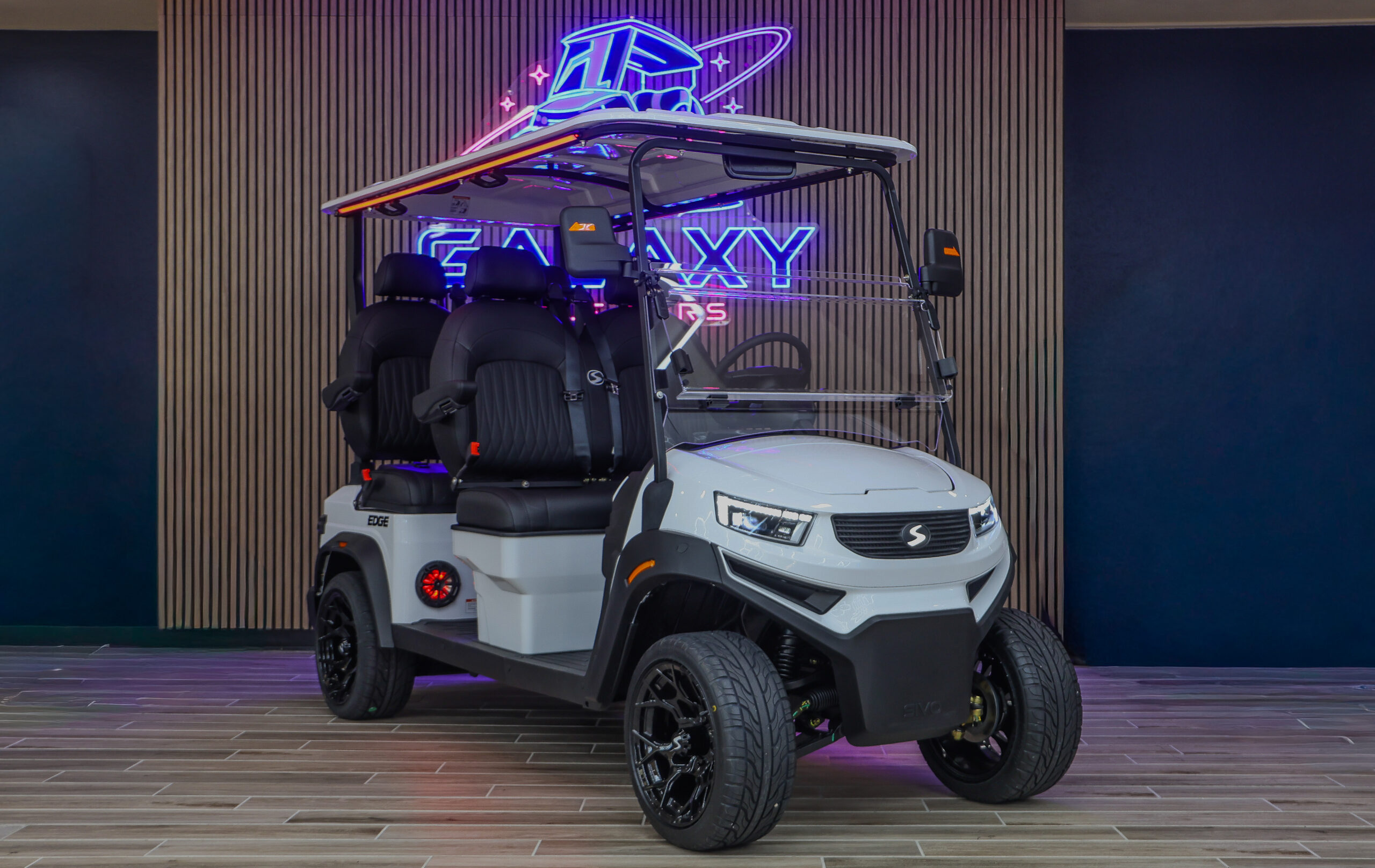 White Sivo Edge 4F golf cart with forward-facing seating displayed in the Galaxy Golf Cars showroom