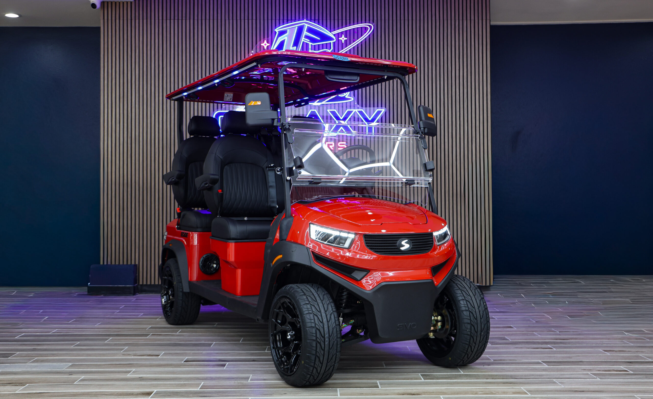 Red Sivo Edge 4F golf cart with forward-facing seating displayed in the Galaxy Golf Cars showroom