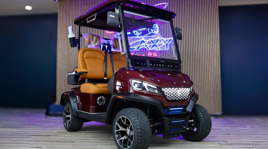 Luxury burgundy golf cart with premium camel seats displayed in the Galaxy Golf Cars showroom